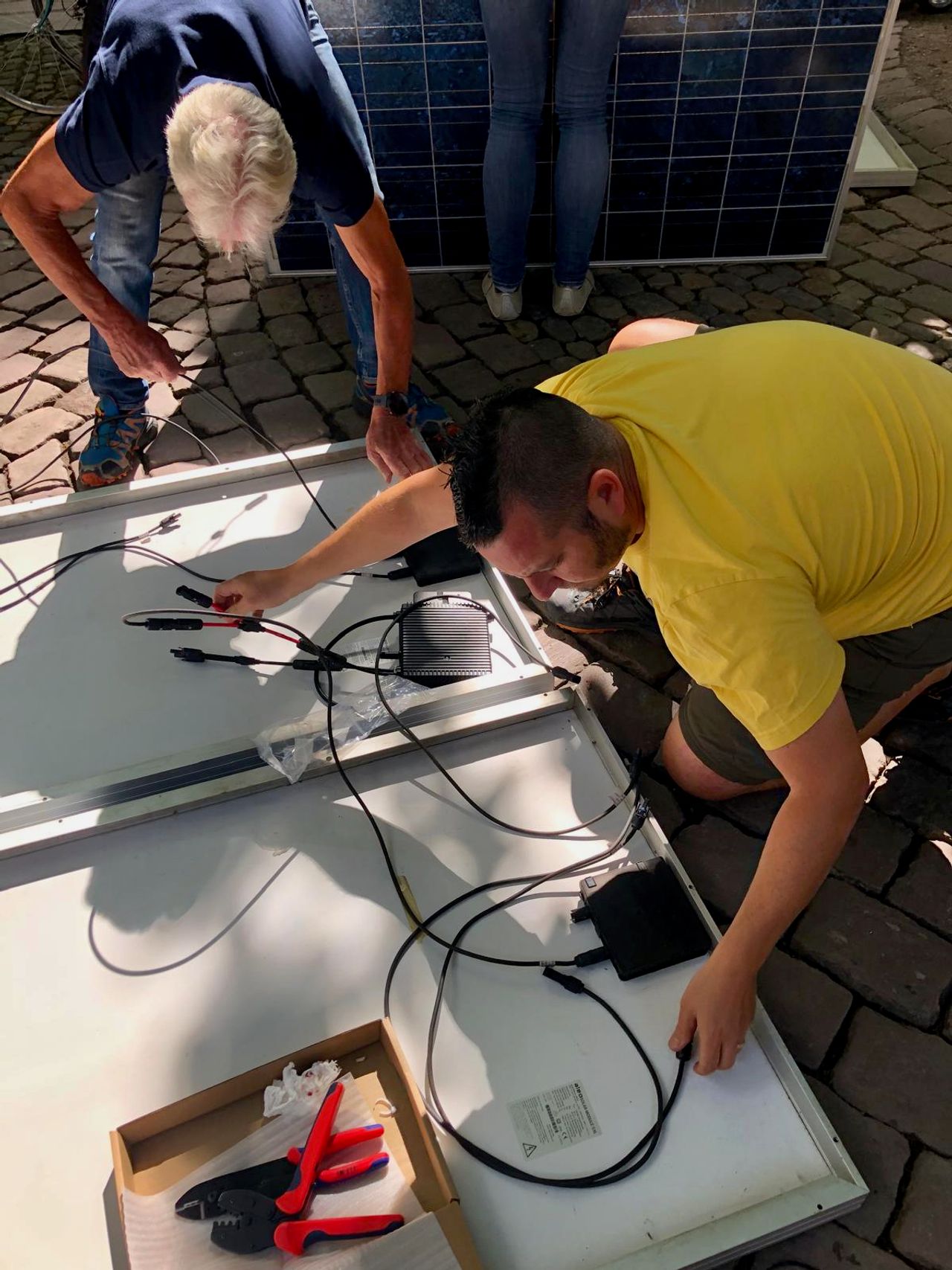 Chris is pictured connecting the solar panel to the inverter.