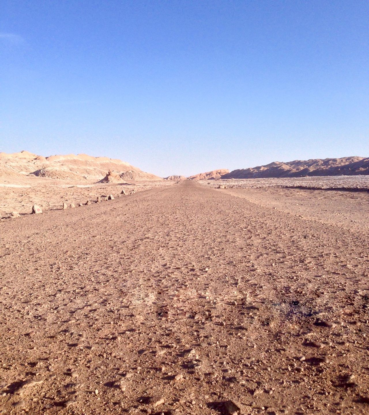 An empty road in a desert valley.