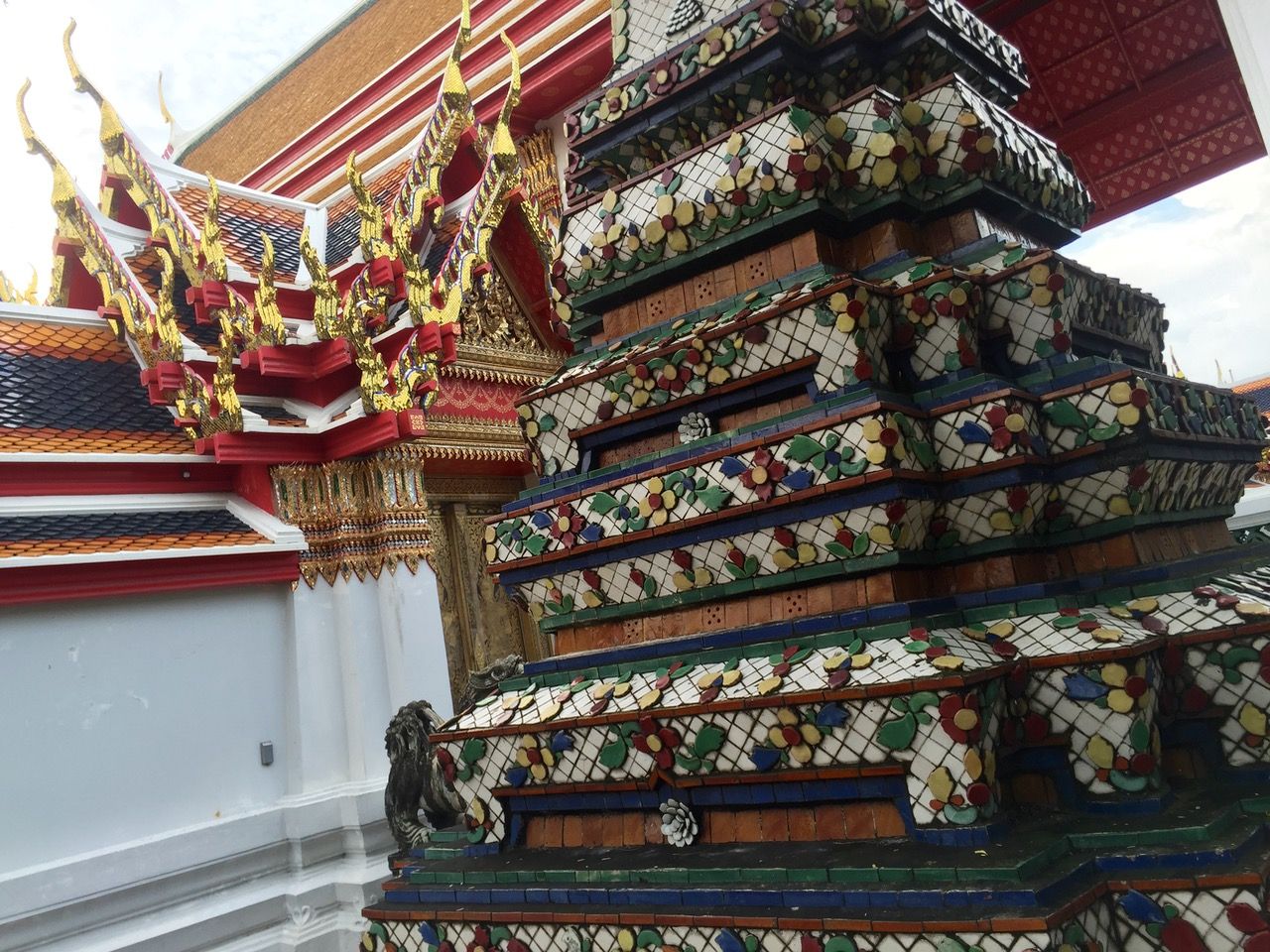 Traditionally decorated Thai Buddhist temple with a ceramic tower next to it.